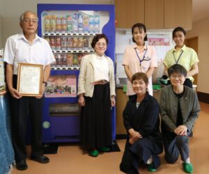 日本セラピューティック・ケア協会、支援型自販機1号導入のデイサービスたまへ感謝状
