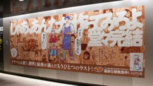 『じゃあ、あんたが作ってみろよ』最終巻発売記念「全体的に茶色すぎる」特大広告が渋谷駅に出現!著者・谷口菜津子氏が描き下ろす勝男・鮎美も登場